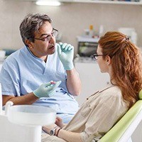 Male dentist talking to female patient about dental care