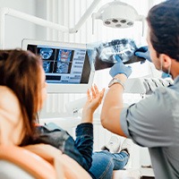 Dentist showing X- rays to patient in dental chair