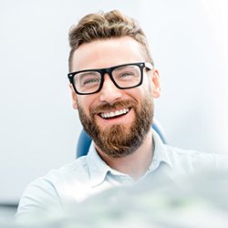 Man sitting in dental chair and smiling