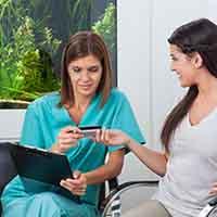 A woman paying for dental implants with a credit card